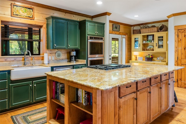 kitchen with sink, a center island, light hardwood / wood-style flooring, appliances with stainless steel finishes, and light stone countertops