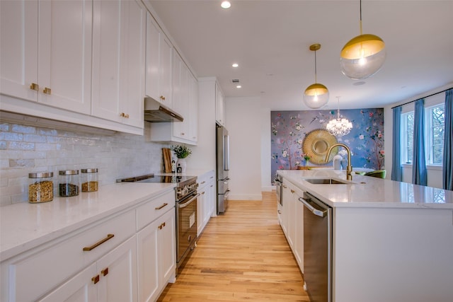 kitchen with sink, decorative light fixtures, white cabinets, and appliances with stainless steel finishes