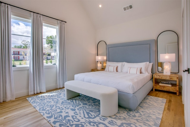 bedroom with vaulted ceiling and light hardwood / wood-style floors