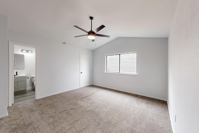 unfurnished bedroom with connected bathroom, vaulted ceiling, ceiling fan, and carpet flooring