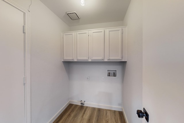 washroom featuring hardwood / wood-style flooring, electric dryer hookup, hookup for a washing machine, cabinets, and hookup for a gas dryer