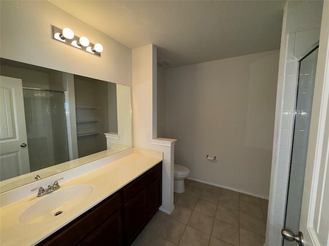 bathroom with toilet, vanity, tile patterned floors, and walk in shower