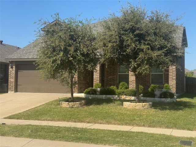 view of property hidden behind natural elements with a garage and a front yard