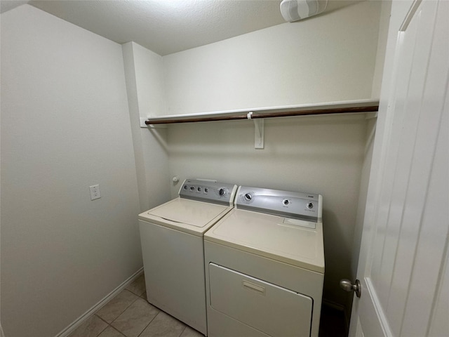 clothes washing area featuring light tile patterned floors and washing machine and dryer