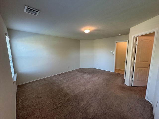 unfurnished room with dark carpet