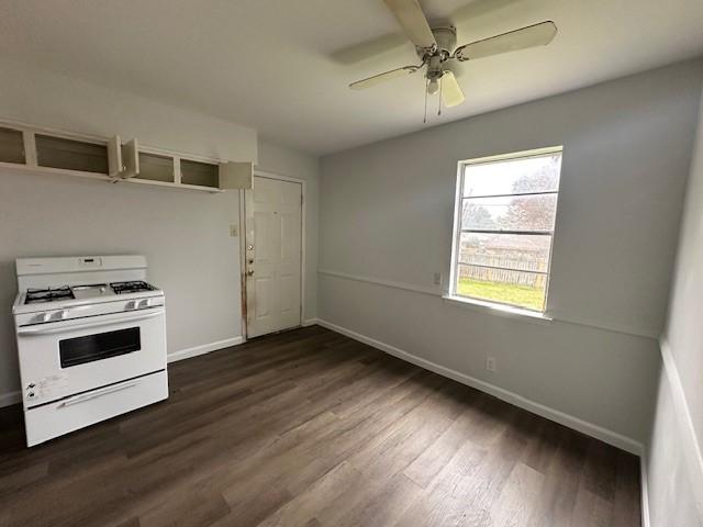 kitchen featuring dark wood-type flooring, white range with gas stovetop, and ceiling fan