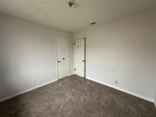 spare room with dark colored carpet