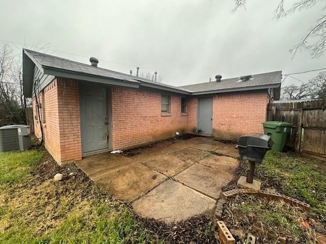 rear view of house with central AC and a patio area