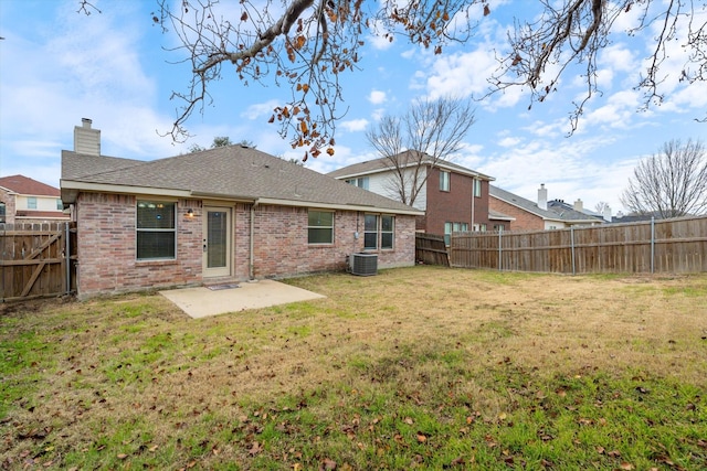 back of property with a lawn and a patio area