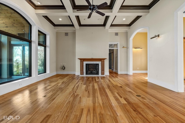 unfurnished living room with crown molding, light hardwood / wood-style flooring, a high ceiling, coffered ceiling, and beamed ceiling