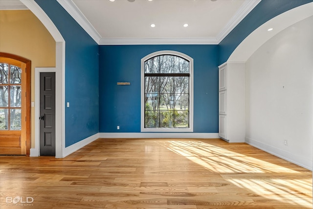 spare room featuring ornamental molding, light hardwood / wood-style floors, and plenty of natural light