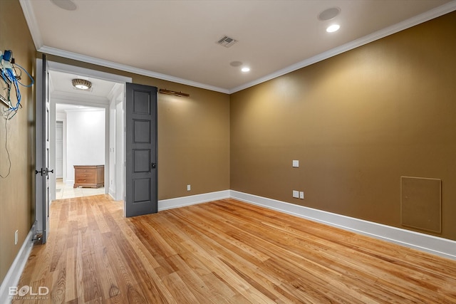 spare room with crown molding and light wood-type flooring