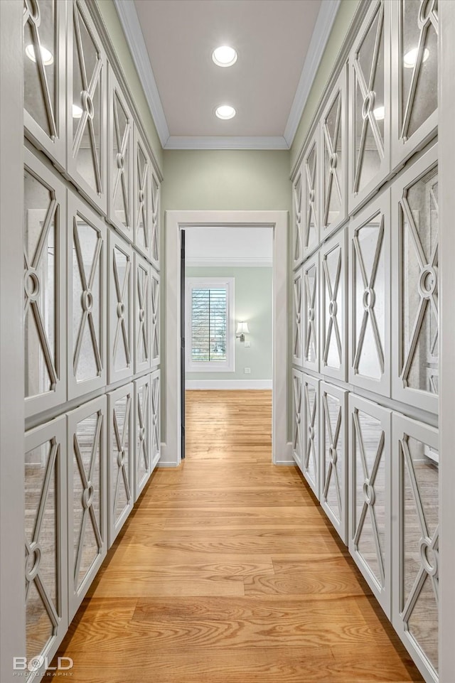 hall with crown molding and light wood-type flooring