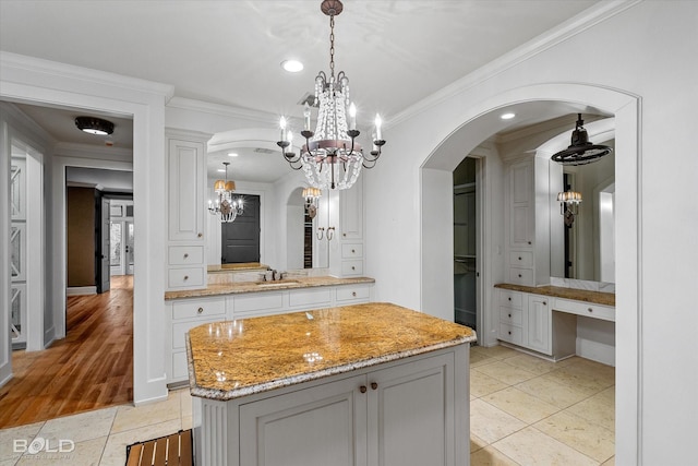 bathroom with tile patterned flooring, ornamental molding, vanity, and an inviting chandelier