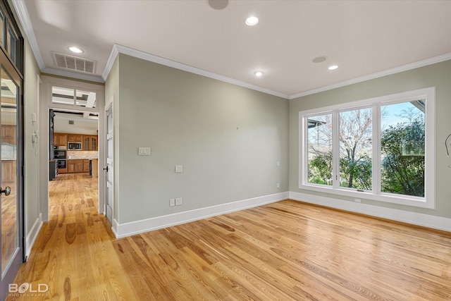 empty room featuring ornamental molding and light hardwood / wood-style flooring