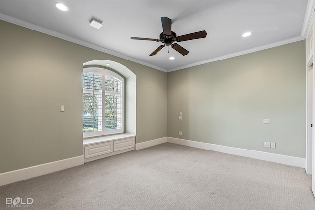 empty room featuring ornamental molding, light colored carpet, and ceiling fan