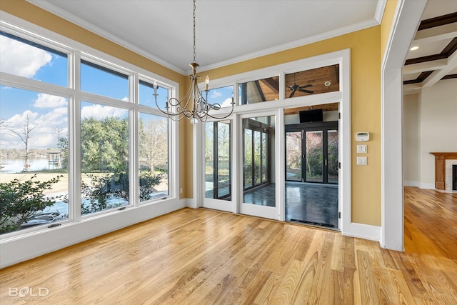 unfurnished sunroom featuring beam ceiling and a chandelier