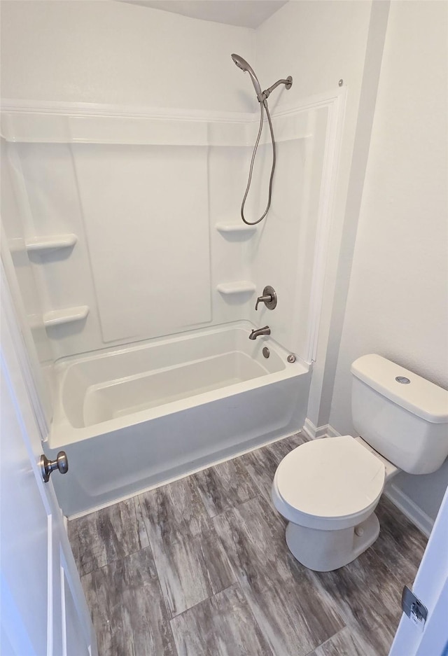 bathroom featuring hardwood / wood-style floors, shower / bathtub combination, and toilet