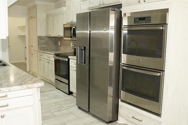 kitchen featuring stainless steel appliances, ornamental molding, backsplash, and light stone counters