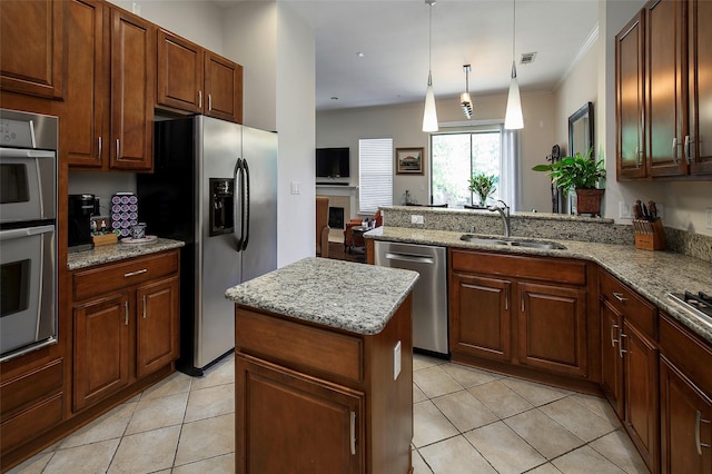 kitchen with sink, hanging light fixtures, kitchen peninsula, a kitchen island, and stainless steel appliances