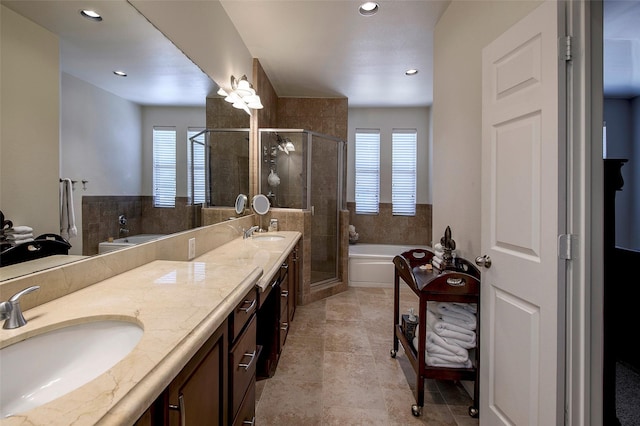 bathroom with vanity, shower with separate bathtub, and a wealth of natural light