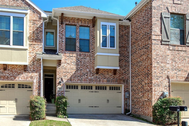 townhome / multi-family property featuring concrete driveway, a shingled roof, an attached garage, and brick siding