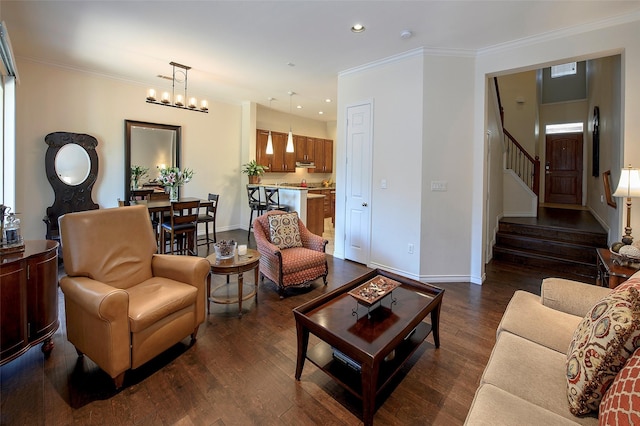 living room featuring crown molding, dark hardwood / wood-style floors, and an inviting chandelier