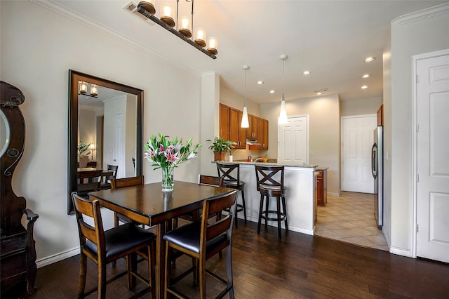 dining room with wood-type flooring and ornamental molding