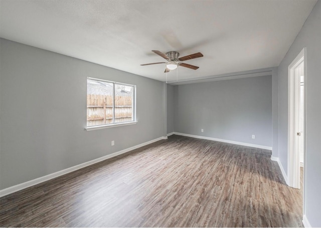 empty room with ceiling fan and dark hardwood / wood-style flooring