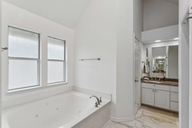 bathroom with lofted ceiling, vanity, and a washtub