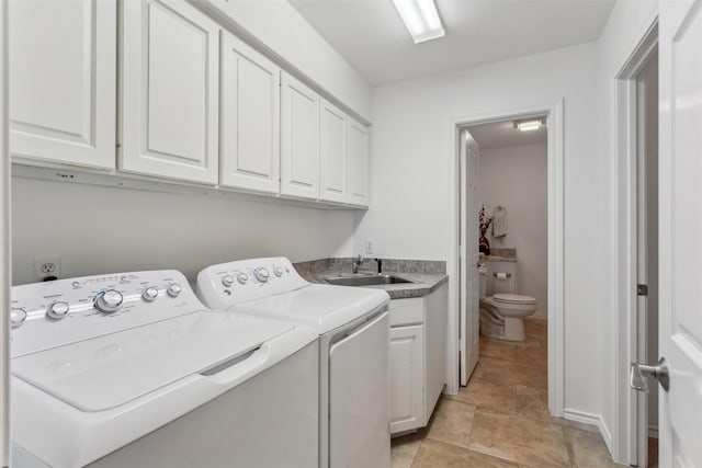 clothes washing area with cabinets, sink, and independent washer and dryer