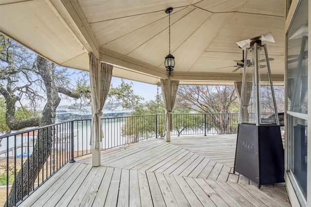 wooden deck featuring a water view and ceiling fan