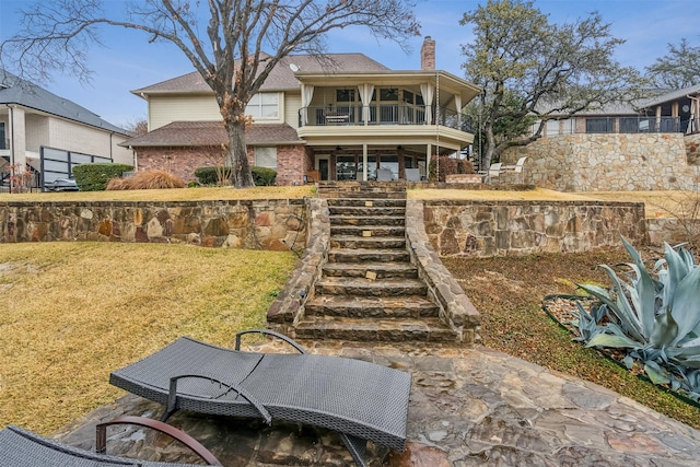 view of front of home featuring a balcony and a front lawn