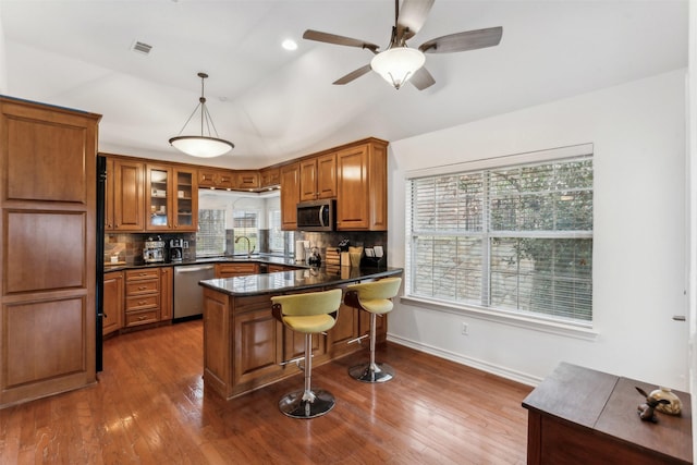 kitchen with stainless steel appliances, tasteful backsplash, pendant lighting, and kitchen peninsula