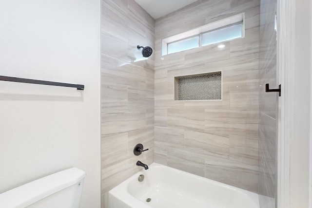 bathroom featuring tiled shower / bath and toilet