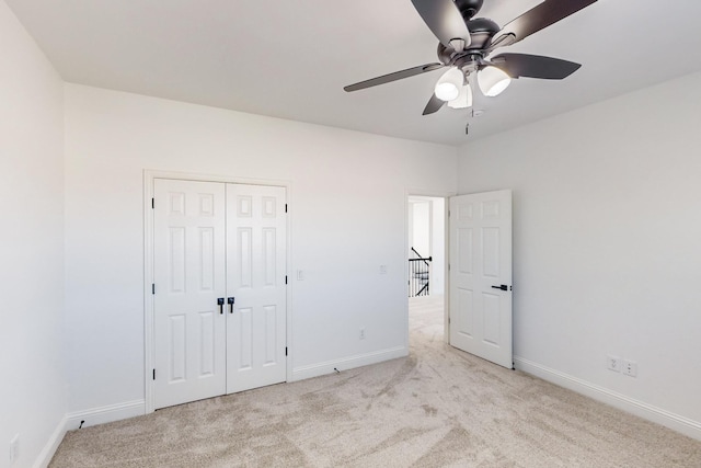 unfurnished bedroom featuring light carpet, a closet, and ceiling fan