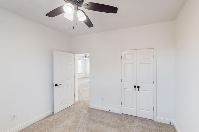 unfurnished bedroom featuring light carpet, ceiling fan, and a closet