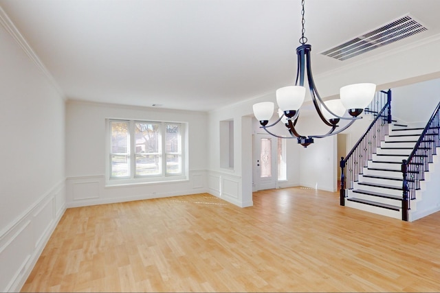 interior space with ornamental molding, wood-type flooring, and a chandelier