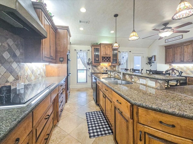 kitchen featuring light tile patterned flooring, sink, hanging light fixtures, black appliances, and wall chimney exhaust hood