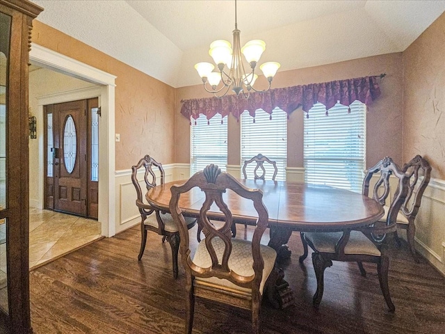 dining area featuring vaulted ceiling, dark hardwood / wood-style floors, and a chandelier