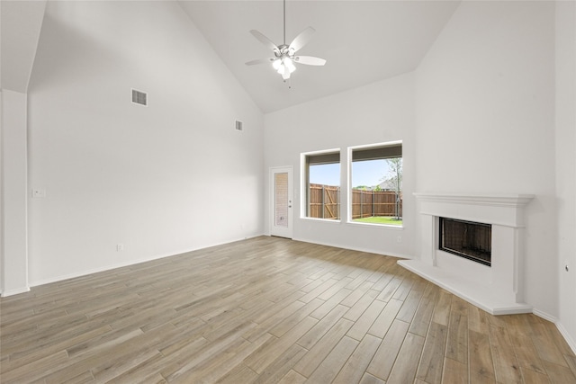3046 Arbor Grv, Midlothian, TX 76065 - unfurnished living room with high vaulted ceiling, light wood-type flooring, ceiling fan, and a fireplace with raised hearth