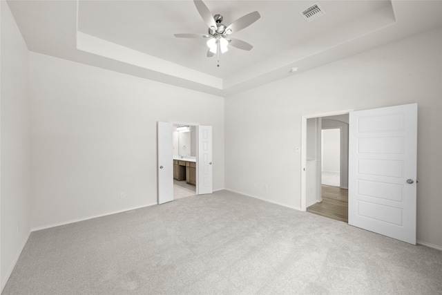 3046 Arbor Grv, Midlothian, TX 76065 - unfurnished bedroom featuring a tray ceiling, carpet floors, connected bathroom, and ceiling fan