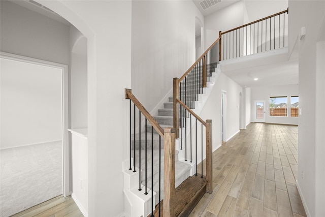 3046 Arbor Grv, Midlothian, TX 76065 - staircase featuring wood finished floors, arched walkways, and a high ceiling