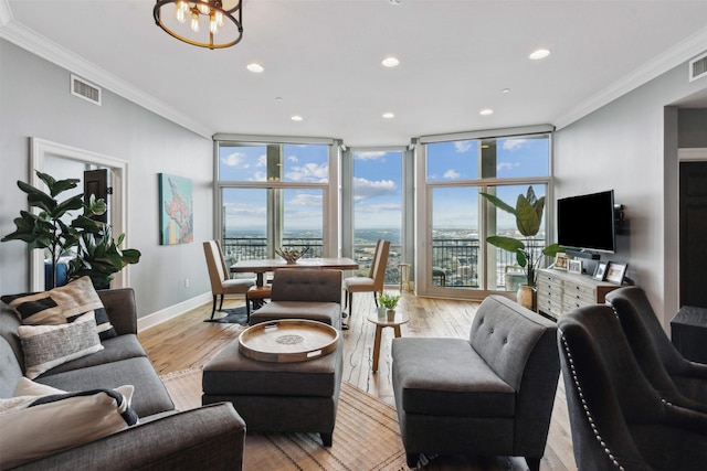 living room featuring ornamental molding, floor to ceiling windows, light hardwood / wood-style flooring, and a notable chandelier