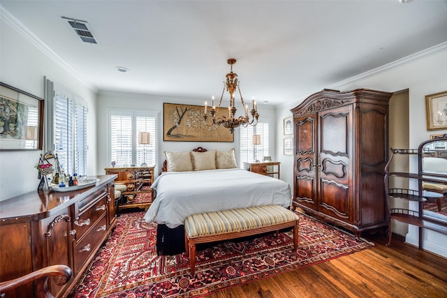 bedroom featuring dark hardwood / wood-style flooring, ornamental molding, and an inviting chandelier