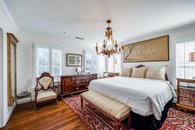 bedroom with dark hardwood / wood-style flooring, multiple windows, ornamental molding, and an inviting chandelier