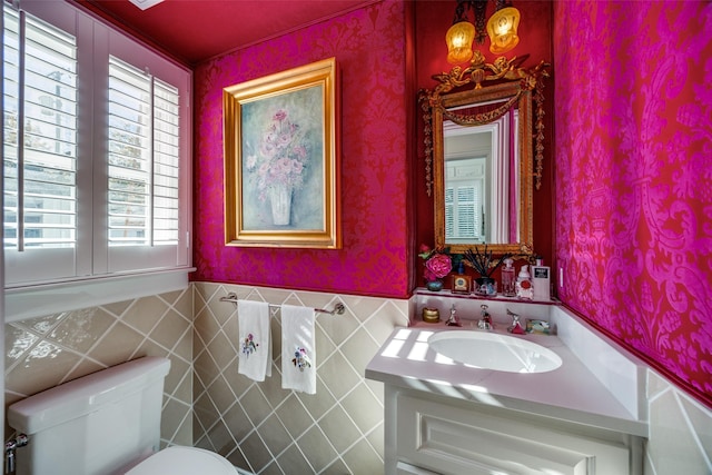 bathroom with vanity, tile walls, and toilet