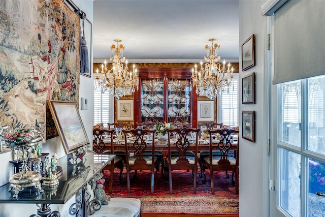 dining room with ornamental molding, a barn door, and a chandelier