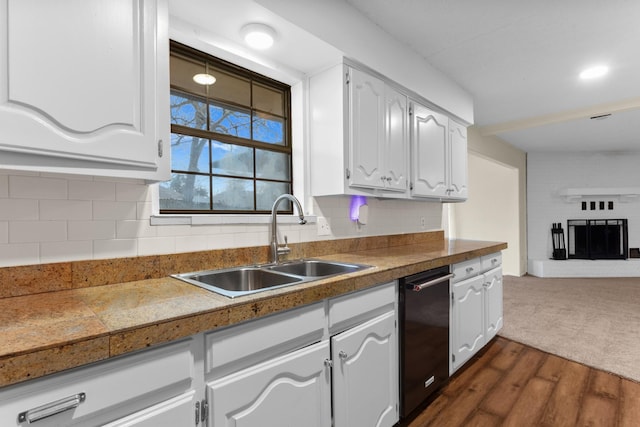 kitchen featuring a brick fireplace, sink, dark wood-type flooring, and white cabinets