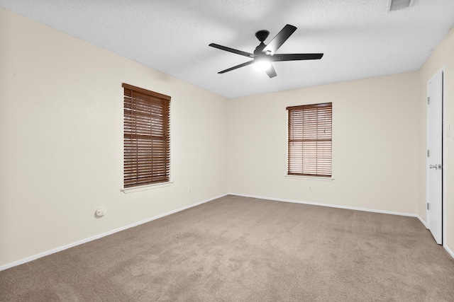 carpeted spare room with ceiling fan and a textured ceiling